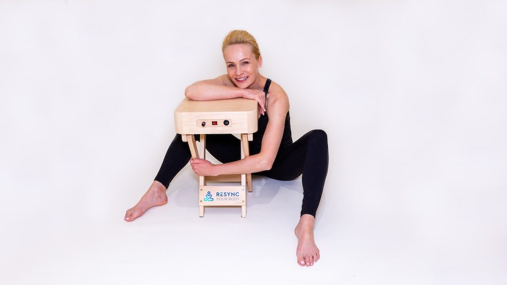 A woman is doing yoga on the beach
