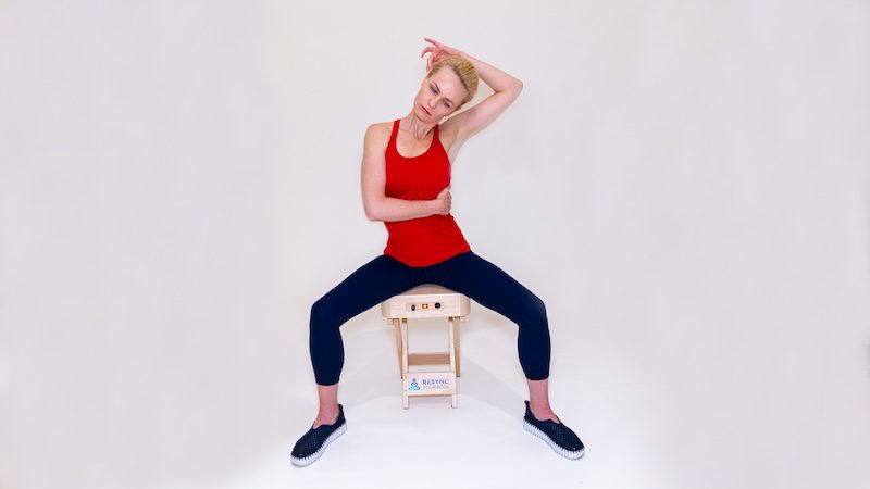 A woman is doing yoga on the beach